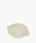 A white ceramic colander features a smooth finish and two handles, with evenly spaced drainage holes, conveying a minimalistic and functional design. | SW Home