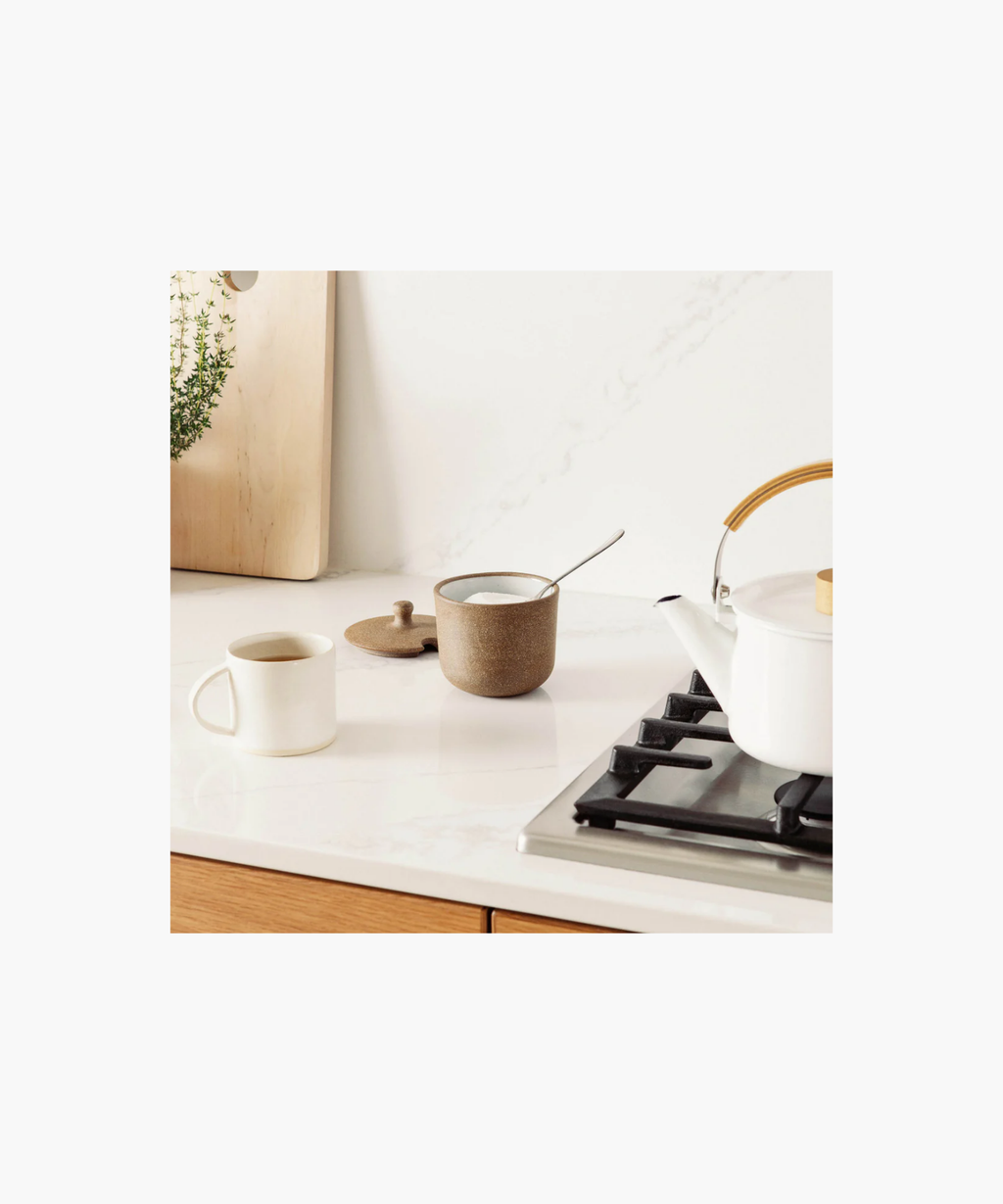 A rustic brown ceramic sugar jar with a speckled texture styled with sugar and a cup of coffee conveying a cozy, earthy vibe. | Wildwood Home Co. 