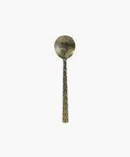 Antique inspired metal spoon with a textured handle featuring a leaf pattern. The spoon has a tarnished, rustic appearance, evoking a sense of history and nostalgia. | Wildwood Home Co.