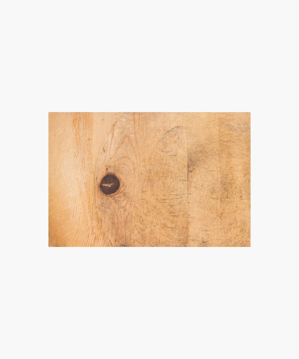 Cross section of a rustic, wooden cutting board with a worn texture suggests frequent use, conveying a homely, vintage feel.