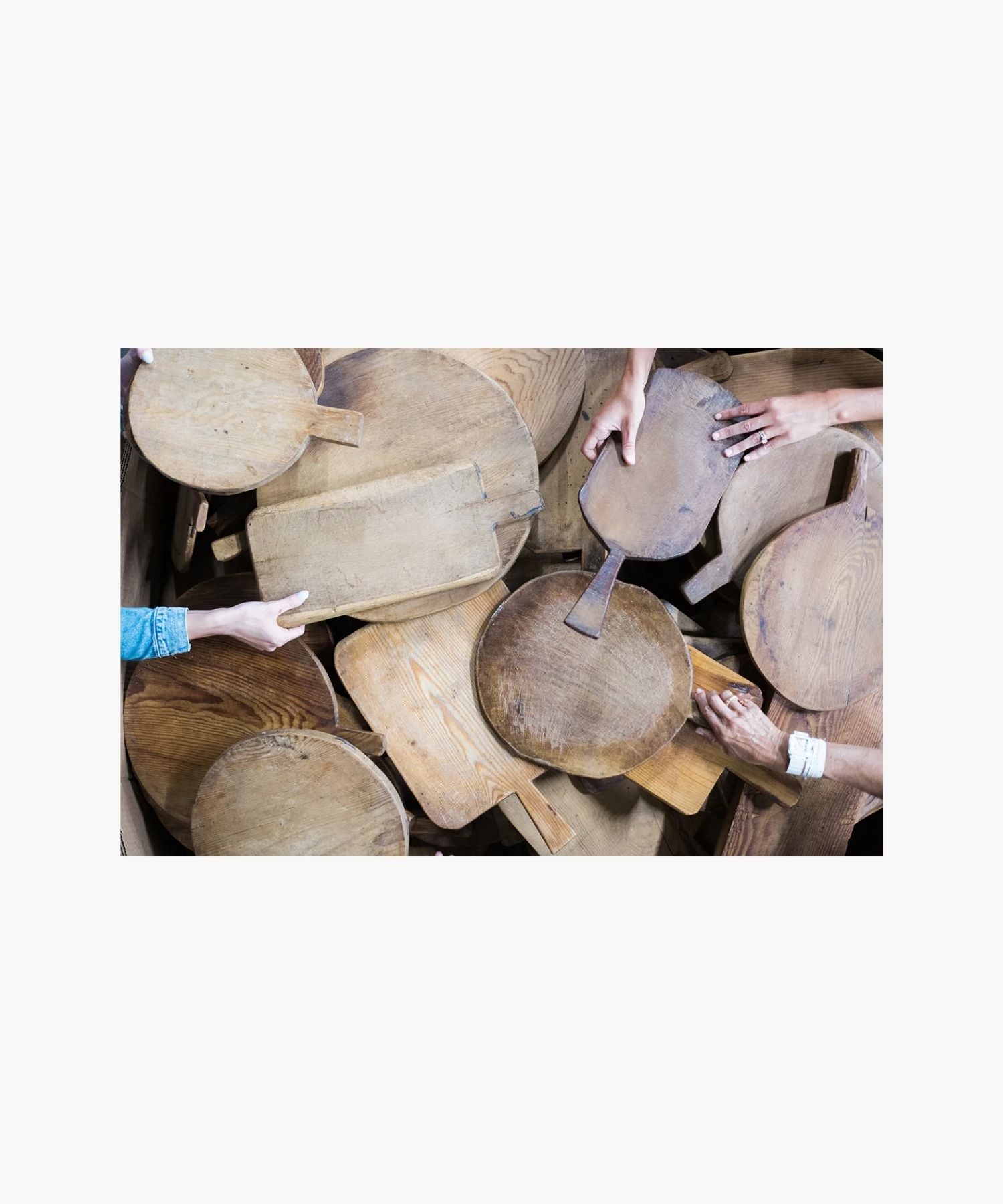 Rustic wooden cutting boards of varying shapes and sizes. Their worn texture suggests frequent use, conveying a homely, vintage feel.