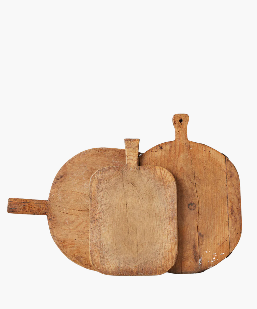 Three rustic, wooden cutting boards of varying shapes and sizes overlap. Their worn texture suggests frequent use, conveying a homely, vintage feel. | SW Home