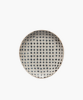 A round ceramic spoon rest with a white background features a repeating pattern of small, dark blue cross shapes, creating a rustic and elegant look. | Wildwood Home Co.