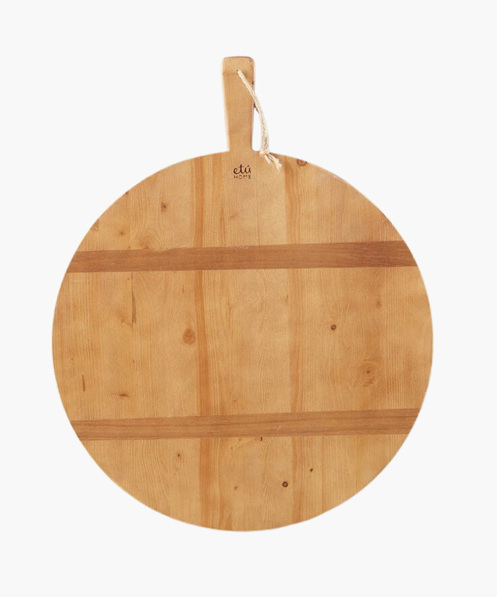 A round pine wood cutting or charcuterie board with a smooth surface and natural grain. It has a handle with a rope loop for hanging, conveying a rustic charm. | SW Home