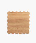 Scalloped-edge wooden cutting board with a light oak finish. | SW Home