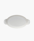Oval white ceramic dish with two ridged handles. The dish is empty and centered on a plain white background, conveying simplicity and elegance. | Wildwood Home Co.